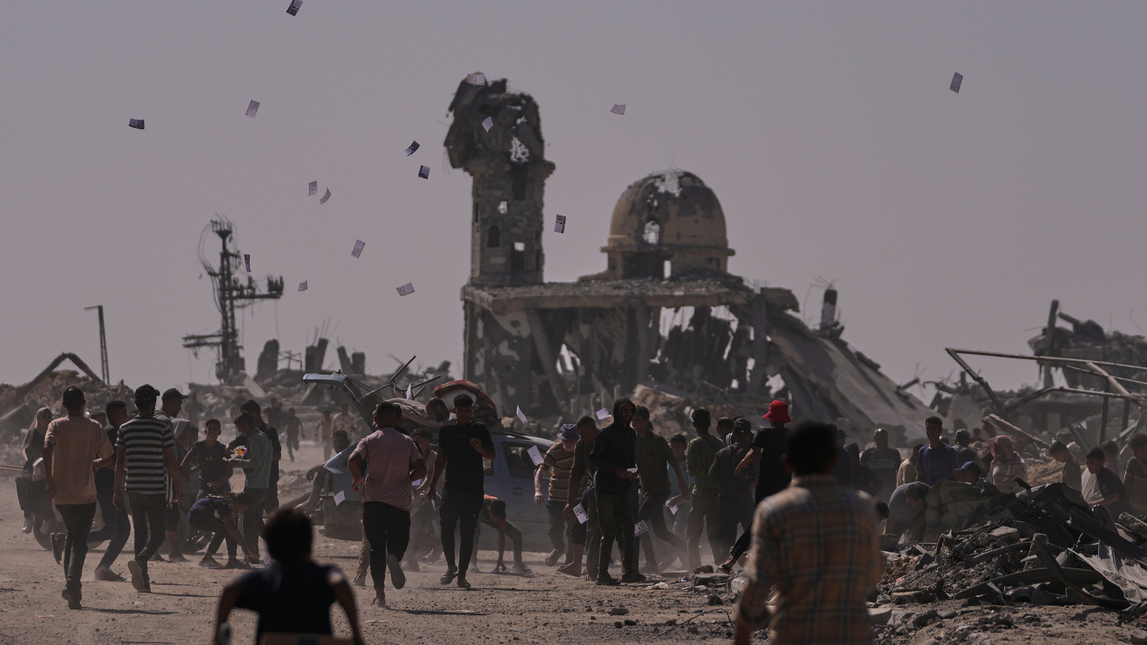 Palestinians collect leaflets dropped by an Israeli drone warning people to stay away from the so-called yellow line in Khan Younis, in the southern Gaza Strip, Monday, Oct. 20, 2025. (AP Photo/Jehad Alshrafi)
