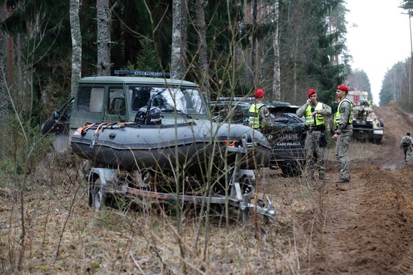 Lithuanian military police stand near military and other vehicles parked at a training range in Pabrade, north of the capital Vilnius, Lithuania on Thursday, March 27, 2025. (AP Photo/Mindaugas Kulbis)