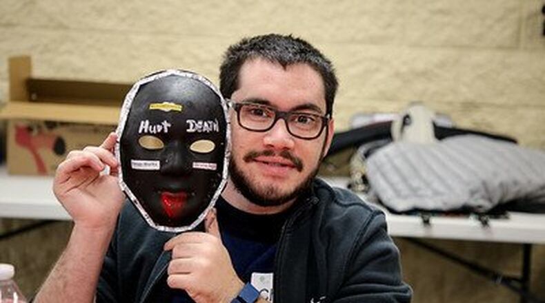 Chase Gottlieb shows off his artistry at the Unmasking Brain Injury Project last week in Suwanee. The effort to raise awareness about brain injuries was hosted by New Beginnings Brain Injury Support Group. The original works of art will be showcased at the Hudgens Center for the Arts in March for Brain Injury Awareness Month as part of their Healing Arts Program before becoming part of a permanent art collection that travels across the country. CONTRIBUTED BY JENNIFER MOTTOLA / EAST2WESTCREATIVE