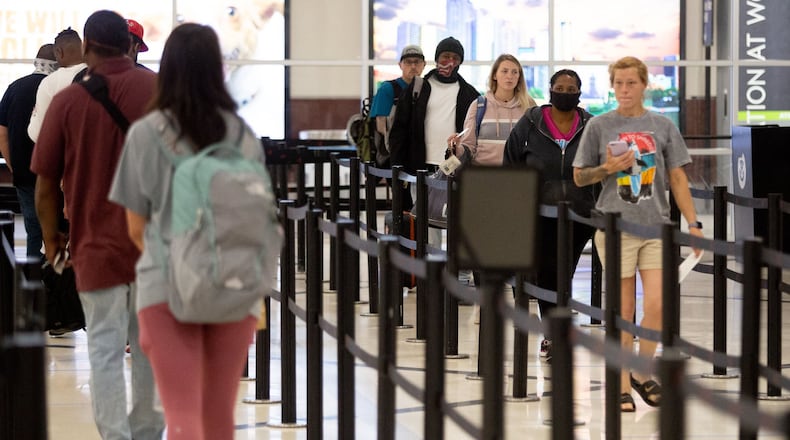 Passengers stand in line waiting to pass through security Sunday at Hartsfield-Jackson Atlanta International Airport on May 3, 2020. STEVE SCHAEFER / SPECIAL TO THE AJC