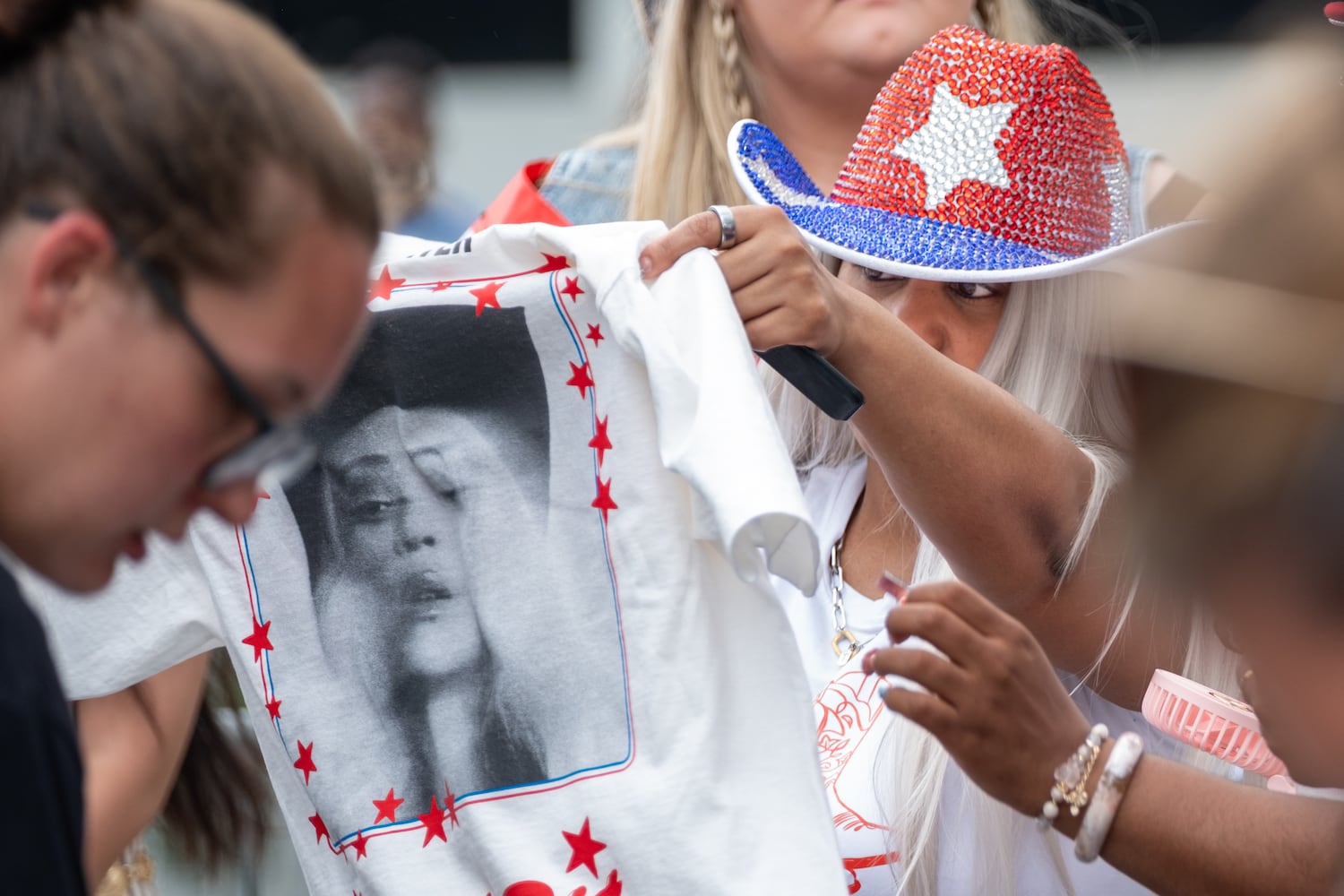 Leidy Thompson, from Jacksonville, checks out a t-shirt while shopping one of the official vendors outside of at Mercedes-Benz Stadium before  Beyoncè’s “Cowboy Carter” show Friday, July 11, 2025.   Ben Gray for the Atlanta Journal-Constitution