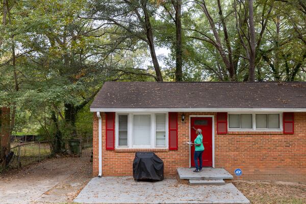 Canvasser Linda McIntosh knocks on a door to promote the city’s WeatheRISE weatherization program in Atlanta Friday, October 27, 2023. (Arvin Temkar / arvin.temkar@ajc.com)
