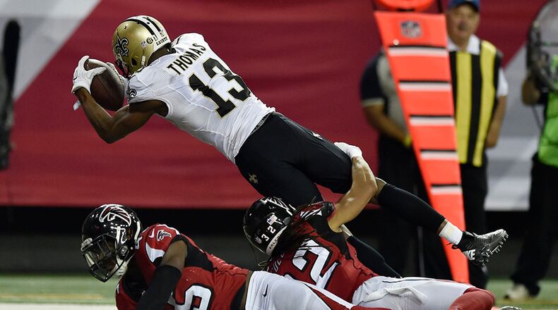 Saints wide receiver Michael Thomas (13) jumps into the end zone over two Falcons defenders in the second half of the final regular season game at the Georgia Dome against the Saints Sunday, Jan.1, 2017, in Atlanta.