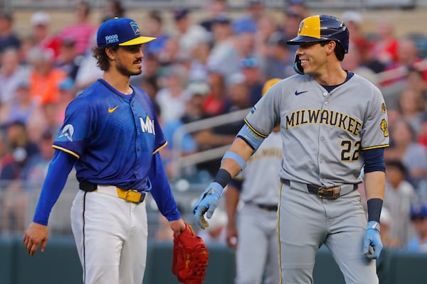 Milwaukee Brewers' Christian Yelich, right, laughs with Minnesota Twins starting pitcher Joe Ryan after his broken bat nearly drilled the starter in the fourth inning of a baseball game Friday, June 20, 2025, in Minneapolis. Ryan threw out Yelich on the play. (AP Photo/Bruce Kluckhohn)