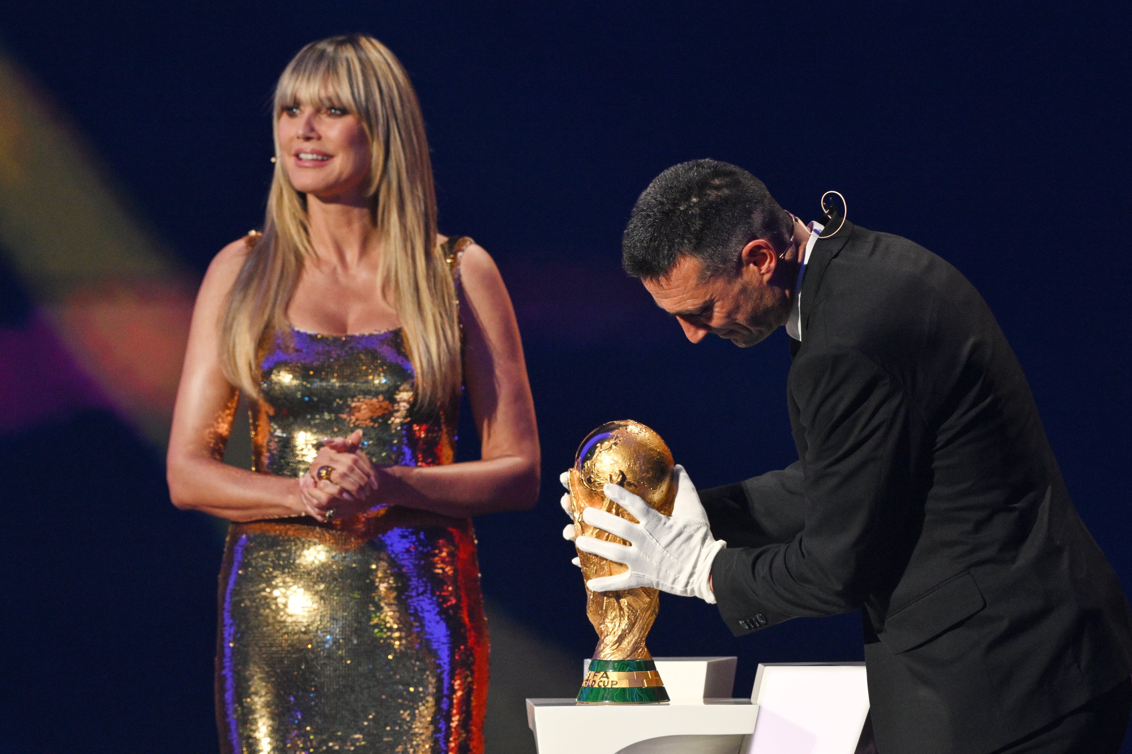 Model Heidi Klum watches as Argentina's coach Lionel Scaloni returns the World Cup trophy to the stage during the draw for the 2026 soccer World Cup at the Kennedy Center in Washington, Friday, Dec. 5, 2025 (Mandel Ngan/Pool Photo via AP)