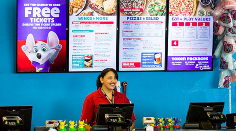 Employee Adrianna Morales stands at the counter in front of a new digital menu board at Chuck E Cheese on Wednesday, April 8, 2015 in Irving, Texas. (Ashley Landis/The Dallas Morning News/TNS)