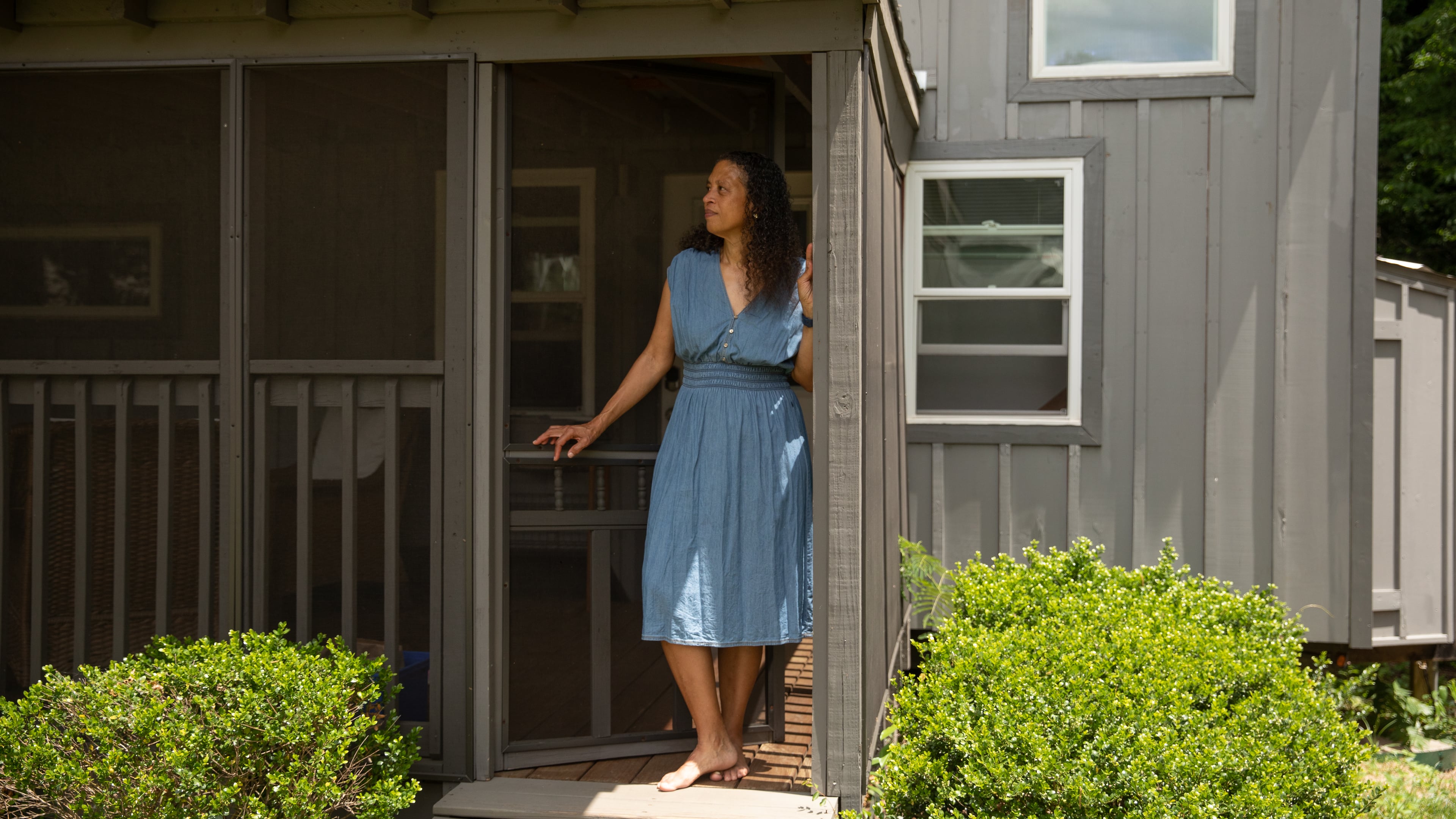 Cabbagetown resident Nadia Giordani stands in the door of her 300-square-foot tiny home in her backyard that she uses as a short-term rental to help her pay for rising property taxes in the area. (Riley Bunch/AJC)
