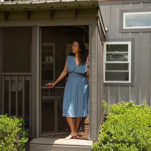 Cabbagetown resident Nadia Giordani stands in the door of her 300-square-foot tiny home in her backyard that she uses as a short-term rental to help her pay for rising property taxes in the area. (Riley Bunch/AJC)