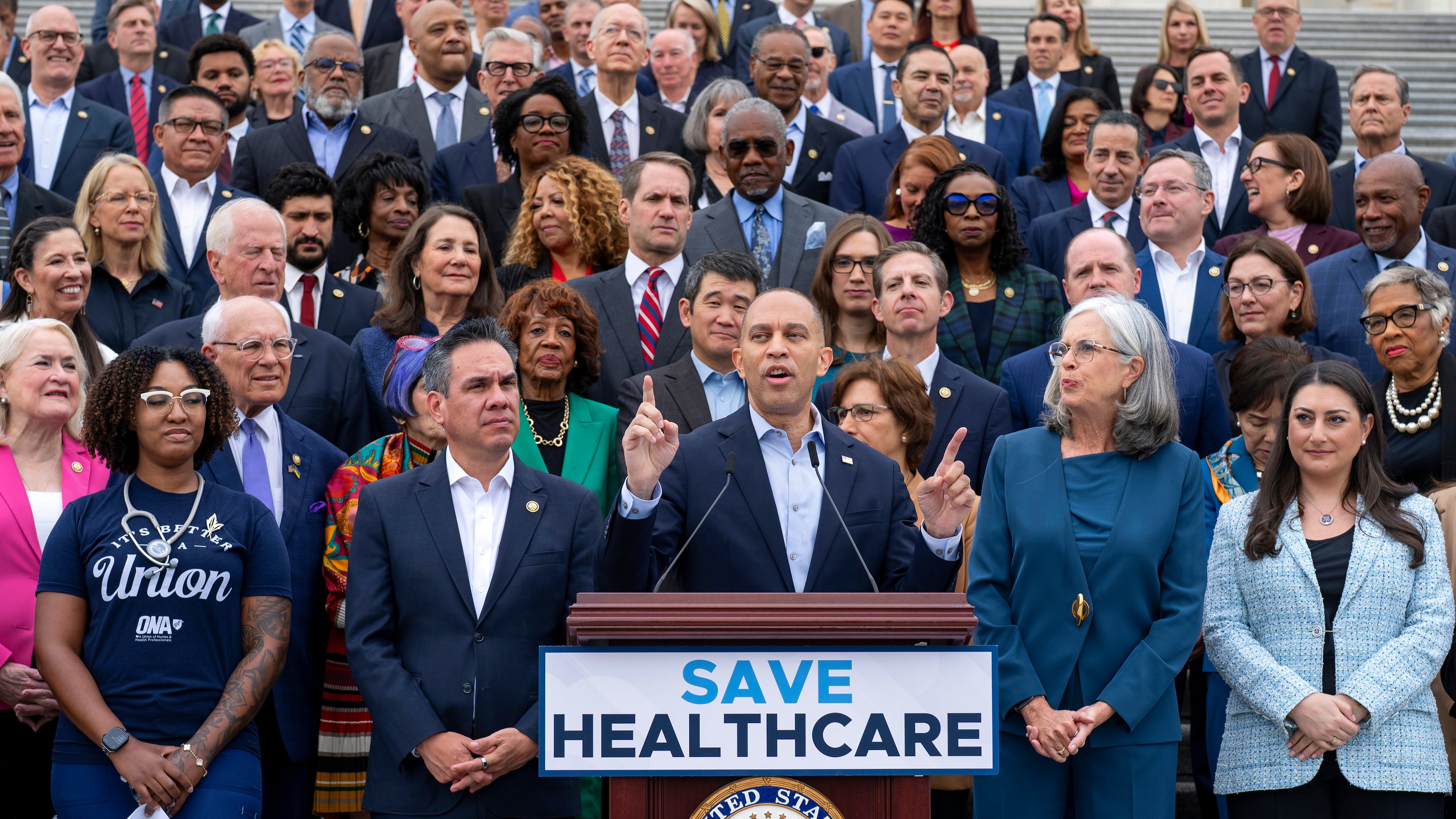 House Minority Leader Hakeem Jeffries, D-N.Y. (center) flanked by colleagues and supporters, presses Democrats' case for extending health care subsidies at a news conference in Washington on Tuesday, Sept. 30, 2025. (J. Scott Applewhite/AP)