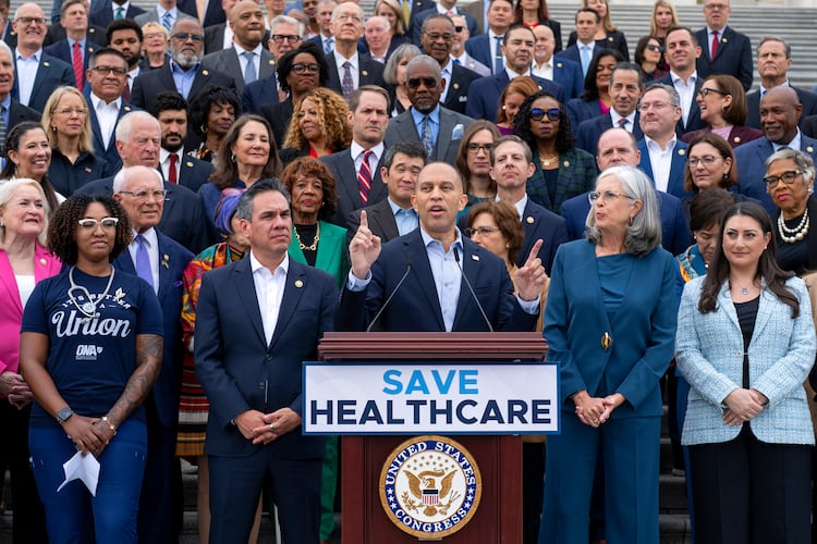 House Minority Leader Hakeem Jeffries, D-N.Y. (center) flanked by colleagues and supporters, presses Democrats' case for extending health care subsidies at a news conference in Washington on Tuesday, Sept. 30, 2025. (J. Scott Applewhite/AP)