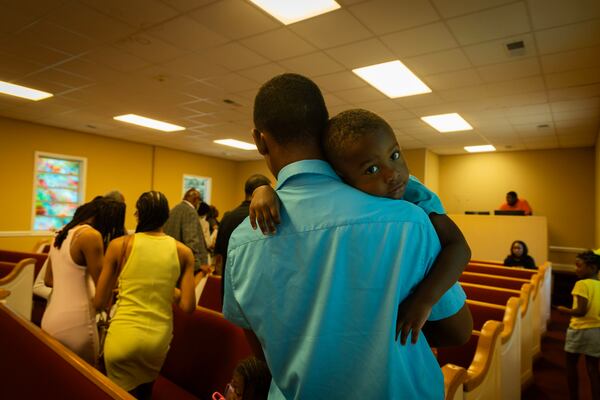 Zy Beasley leans on the shoulder of his father after Sunday service at Holly Grove Baptist Church in Jemison,Ala., on June 16, 2024. (Photo by Jordan Moore/News21)