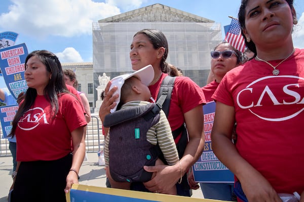 A woman from CASA Maryland holds her 9-month-old baby as she joins others in support of birthright citizenship, Thursday, May 15, 2025, outside of the Supreme Court in Washington. (AP Photo/Jacquelyn Martin)