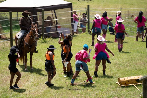 City Mungin, who owns The Outpost West in Winston, sits atop his horse Hennessy as attendees of a Cowboys and Creatives event gather around him and take photos Saturday, April 19, 2025. (Ben Gray for The Atlanta Journal-Constitution)