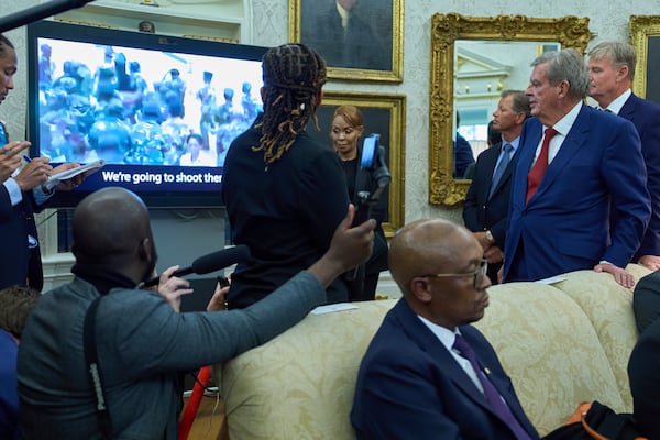 South African businessman Johann Rupert, standing right, watches a video during a meeting between President Donald Trump and South African President Cyril Ramaphosa in the Oval Office of the White House, Wednesday, May 21, 2025, in Washington. (AP Photo/Evan Vucci)