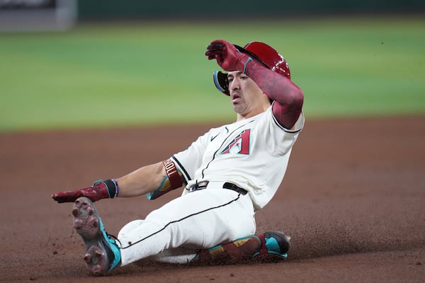 Arizona Diamondbacks' Corbin Carroll slides safely into third base with a triple against the Atlanta Braves during the first inning of a baseball game Sunday, April 27, 2025, in Phoenix. (AP Photo/Ross D. Franklin)