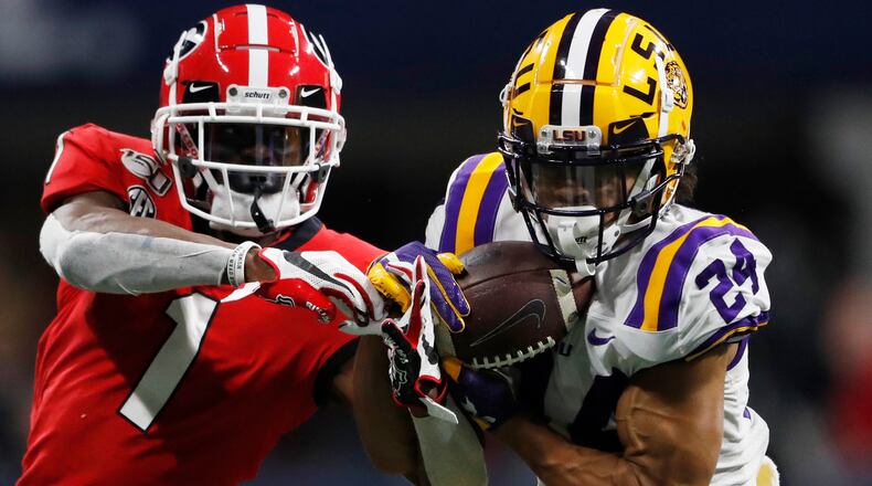 FILE - In this Dec. 7, 2019, file photo, LSU cornerback Derek Stingley Jr. (24) intercepts the ball from Georgia wide receiver George Pickens (1) during the second half of the Southeastern Conference championship NCAA college football game in Atlanta. Southeastern Conference schools will be able to bring football and basketball players back to campus for voluntary activities starting June 8 at the discretion of each university. The SEC’s announcement Friday, May 22, 2020, is the latest sign of encouragement that a college football season in at least some form can go on this fall.(AP Photo/John Bazemore, File)