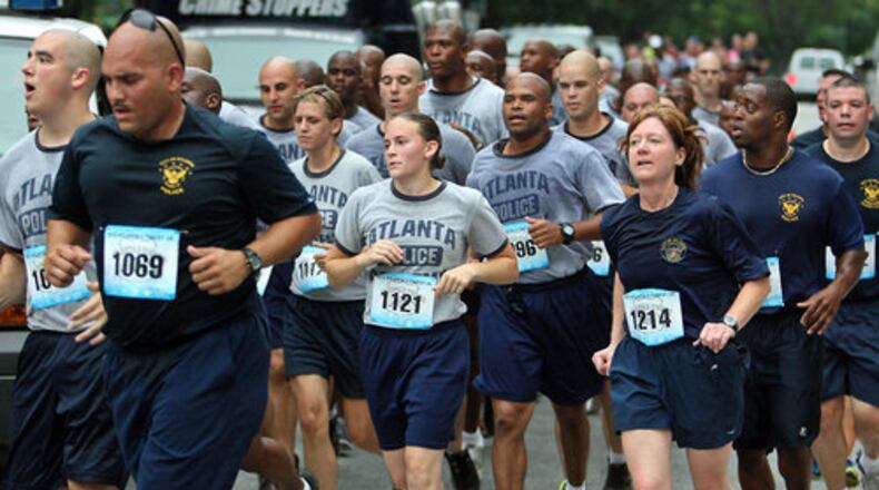 The Atlanta Police Department recruit class runs in formation with instructors (in blue) during Atlanta's Finest 5K in this 2012 file photo.