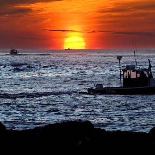 FILE - Lobster fishermen work at sunrise, Sept. 8, 2022, off Kennebunkport, Maine. (AP Photo/Robert F. Bukaty, File)