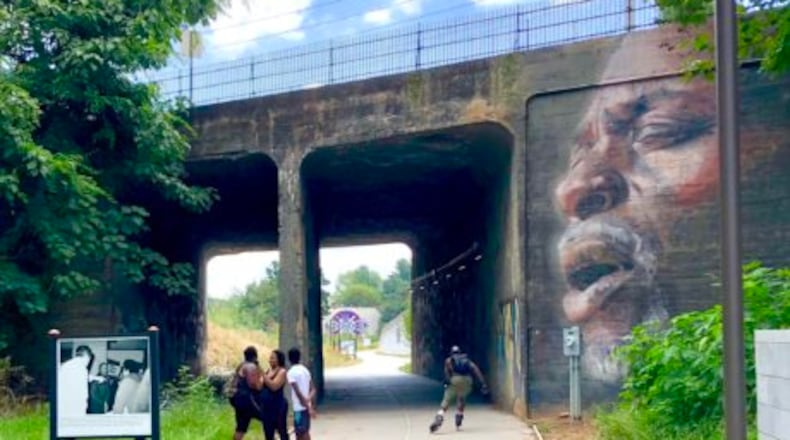 A panel from “Atlanta and the Civil Rights Movement, 1944-1968” on the Westside Trail, alongside “The Singer,” mural by Suzy Schultz. Photo: John Becker
