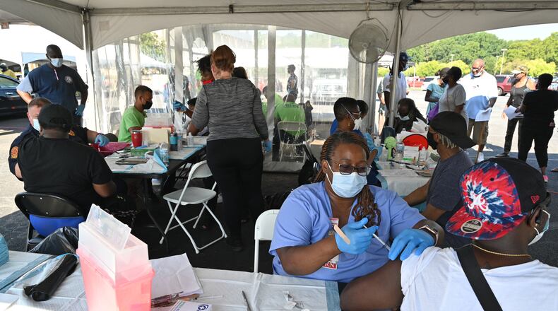 Hattie Ross, a registered nurse with the DeKalb County Board of Health (foreground), administers the COVID-19 vaccine during an event at The Gallery at South DeKalb in Decatur on Saturday, August 13, 2021. More than 1,100 people were vaccinated. (Hyosub Shin / Hyosub.Shin@ajc.com)
