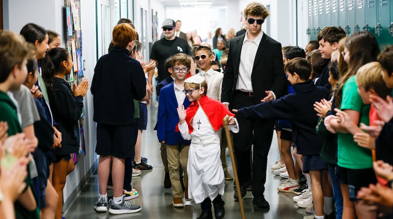 Pope David, also know as second grader David Levergood, waves to middle-schoolers as he tours the school after being elected as the new pontiff during a mock papal conclave at Pinecrest Academy on May 6, 2025. (Miguel Martinez/AJC)