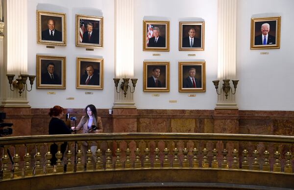 A news crew works in front of a wall of presidential portraits at the Colorado Capitol on Monday, March 24, 2025, in Denver. (AP Photo/Thomas Peipert)
