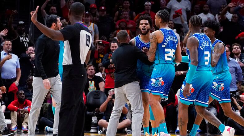 Charlotte Hornets forward Miles Bridges (0) is restrained by P.J. Washington (25) and others as he argues with an official after being charged with a foul during the second half of the team's NBA play-in basketball game against the Atlanta Hawks on Wednesday, April 13, 2022, in Atlanta. Bridges was ejected. (AP Photo/John Bazemore)