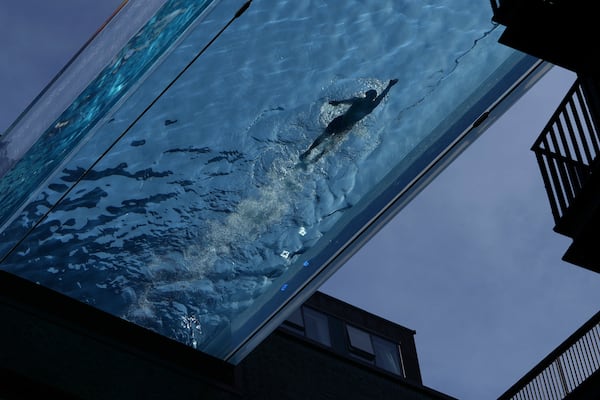 A man swims in the Sky Pool on a sunny day in London, Thursday, May 1, 2025. (AP Photo/Kin Cheung)
