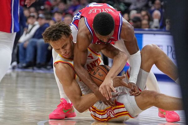 Philadelphia 76ers' Jared Butler, top, and Atlanta Hawks' Dyson Daniels, bottom, vie for the ball during the second half of an NBA basketball game Friday, April 11, 2025, in Philadelphia. (AP Photo/Matt Rourke)