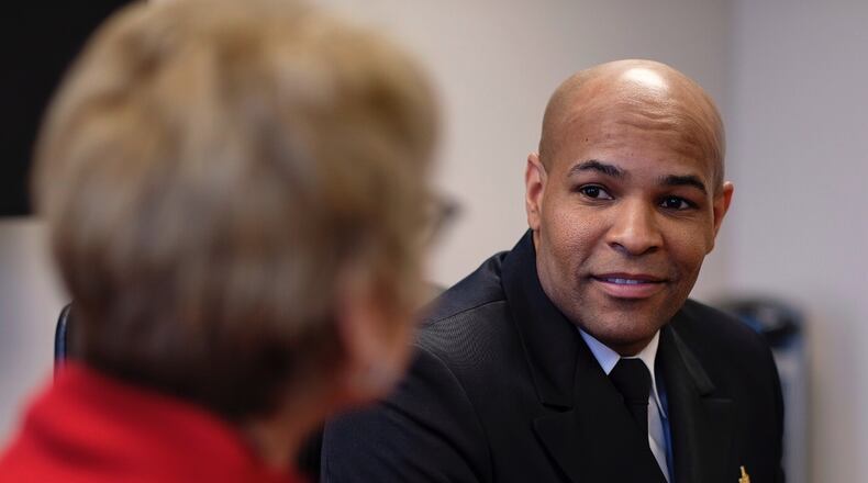 Surgeon General Jerome Adams speaks with State Public Health Commissioner Dr. Kathleen Toomey on Friday, March, 2020 in Atlanta.