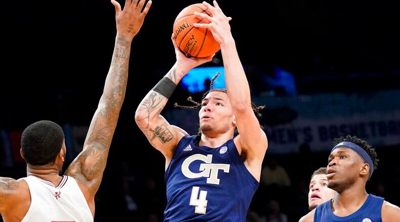 Georgia Tech's Jordan Usher (4) shoots over Louisville's Malik Williams, left, during the first half of an NCAA college basketball game of the Atlantic Coast Conference men's tournament, Tuesday, March 8, 2022, in New York. (AP Photo/John Minchillo)