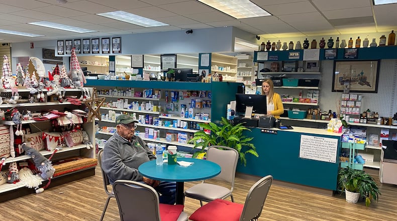 Danica Robertson, owner of Sherwood's Drug Shop, works behind the counter as friend and customer Robert Blan sits and drinks coffee a few feet away, as he's done for decades.
(Keri Janton for The Atlanta Journal-Constitution)