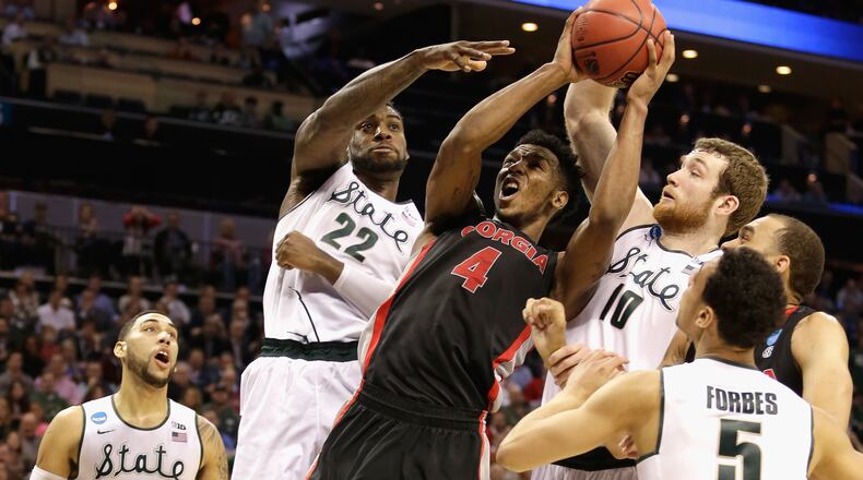 Teammates Branden Dawson #22 and Matt Costello #10 of the Michigan State Spartans try to stop Charles Mann #4 of the Georgia Bulldogs during the second round of the 2015 NCAA Men's Basketball Tournament at Time Warner Cable Arena on March 20, 2015 in Charlotte, North Carolina. (Photo by Bob Leverone/Getty Images)