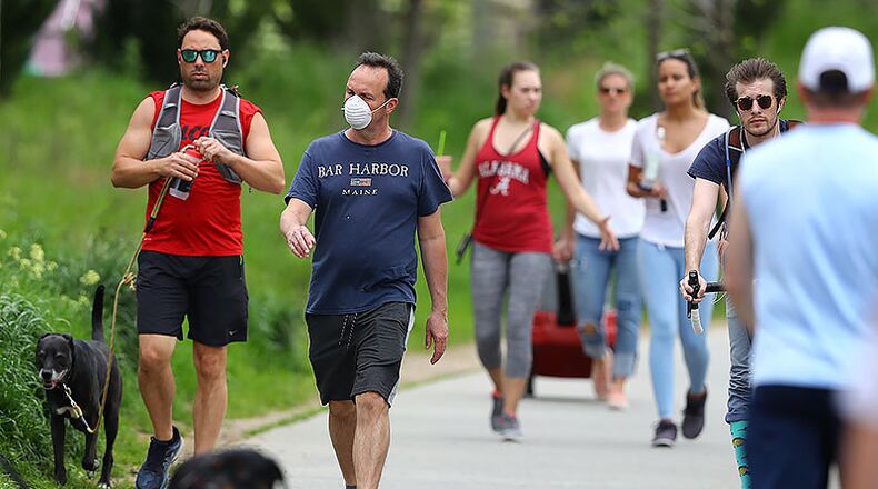 A man wears a mask while walking with the crowd on the Atlanta BeltLine trail on Sunday. Curtis Compton ccompton@ajc.com