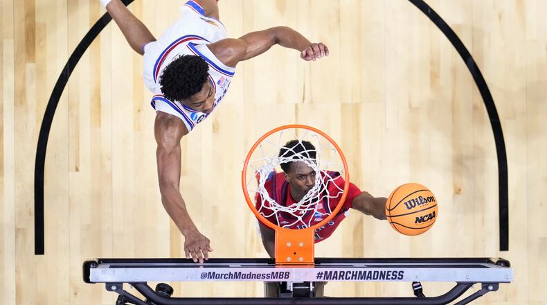 St. John's guard Ian Jackson (11) shoots around Kansas forward Bryson Tiller (15) during a game in the second round of the NCAA college basketball tournament Sunday, March 22, 2026, in San Diego. (AP Photo/Mark J. Terrill)