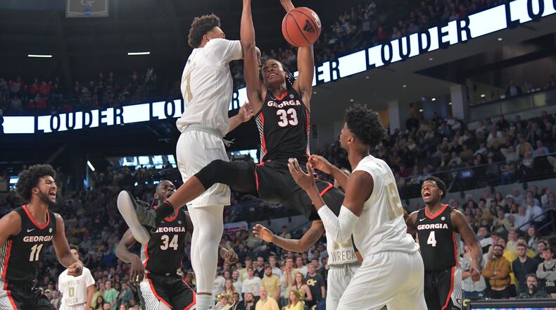 Georgia's Nicolas Claxton (33) hangs on the basket after dunking at Georgia Tech's McCamish Pavilion on December 22, 2018. HYOSUB SHIN / HSHIN@AJC.COM
