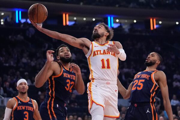 The Hawks' Trae Young drives past Knicks defenders during Wednesday night's NBA Cup victory.