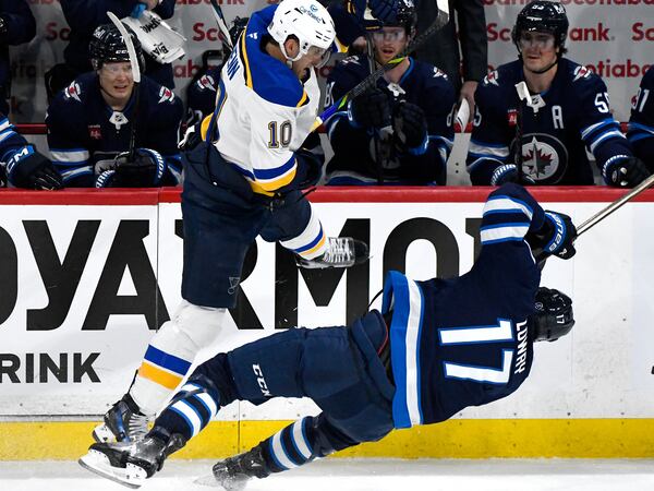St. Louis Blues' Brayden Schenn (10) checks Winnipeg Jets' Adam Lowry (17) during the first period of Game 2 of a first-round NHL hockey playoff series in Winnipeg, Manitoba, Monday April 21, 2025. (Fred Greenslade/The Canadian Press via AP)