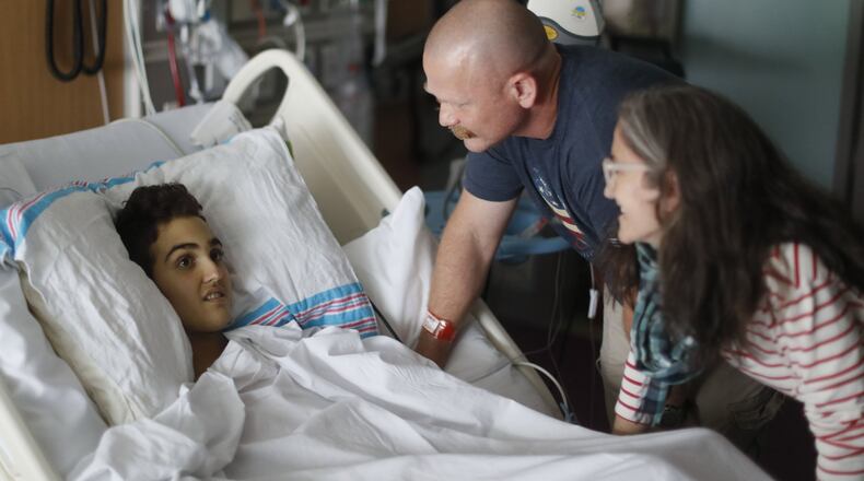May 30, 2019 - Atlanta - Logan Droke and his father, Randall, and step mother, Veronique, spend some time together in his hospital room. Logan, 18, from Canton, facing his fourth battle with leukemia at Children’s Healthcare of Atlanta at Scottish Rite, is set to graduate from Creekview High School on Friday. Firefighters in two departments are rallying behind the teenager by raising money to help pay for treatments. Bob Andres / bandres@ajc.com