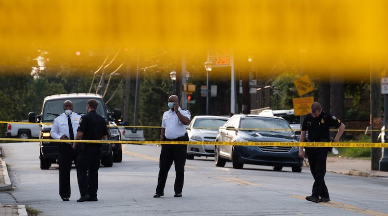 Police investigate the scene in front of Star Discount Food market on Joseph E. Boone Boulevard.