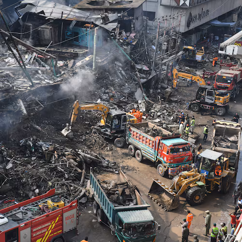 Rescue workers and firefighters work with heavy machinery to search through the rubble of a burnt building of a multistory shopping plaza following a massive fire in Karachi, Pakistan, Monday, Jan. 19, 2026. (AP Photo/Ali Raza)