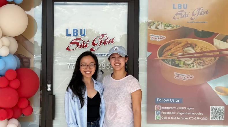 Two women, Trang Vu and her sister Trinh Vu, standing in in front of their noodle shop called LBU Saigon.