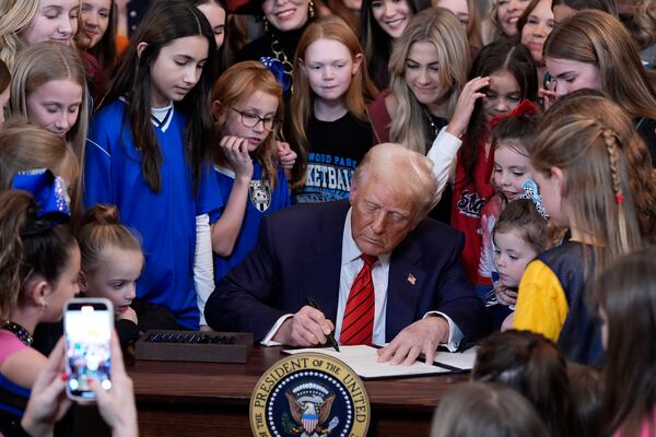 FILE - President Donald Trump signs an executive order barring transgender female athletes from competing in women's or girls' sporting events, in the East Room of the White House, Feb. 5, 2025, in Washington. (AP Photo/Alex Brandon, file)