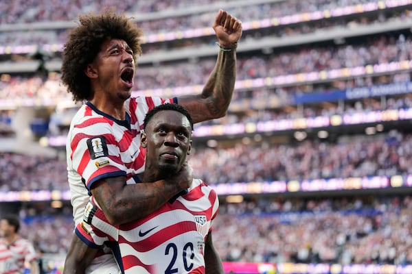 Folarin Balogun gives teammate Chris Richards a celebratory piggyback ride after one of his two goals against Paraguay. (Andre Penner/AP)