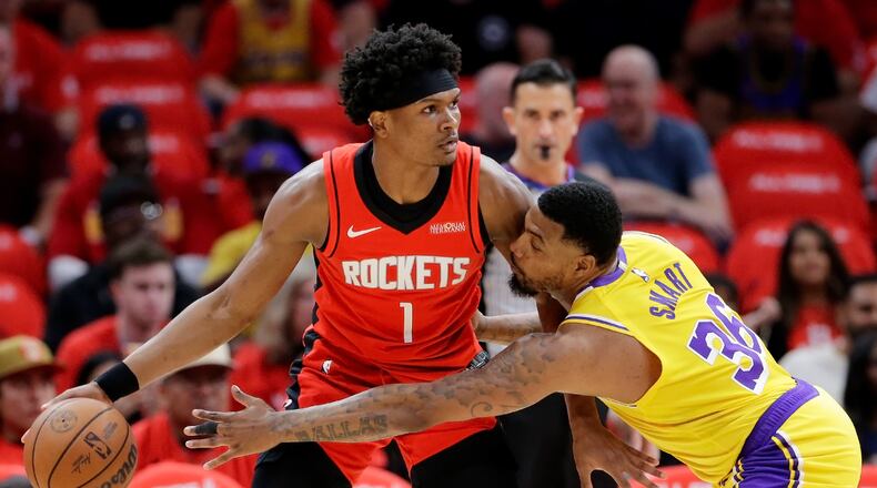 Houston Rockets guard Amen Thompson (1) looks to drive around Los Angeles Lakers guard Marcus Smart (36) who reaches in during the first half of Game 3 in a first-round NBA playoffs basketball series Friday April 24, 2026, in Houston. (AP Photo/Michael Wyke)