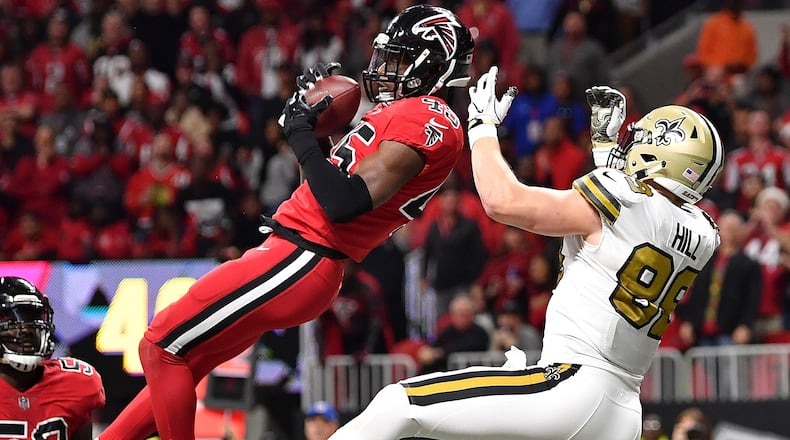 Atlanta Falcons middle linebacker Deion Jones (45) intercepts a ball in the end zone in front of New Orleans Saints tight end Josh Hill (89) during the second half of an NFL football game in Atlanta.  (AP Photo/Danny Karnik, File)