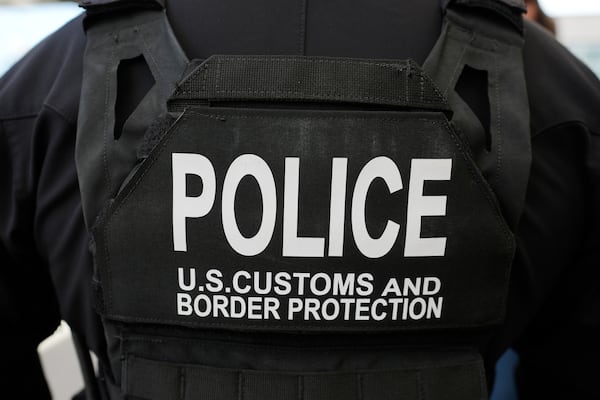 A Customs and Border Patrol officer watches as Homeland Security Secretary Kristi Noem tours the San Ysidro Port of Entry, Sunday, March 16, 2025, in San Diego. (AP Photo/Alex Brandon)