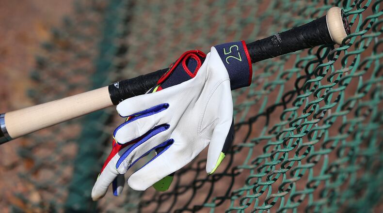 The bat and glove of Braves catcher Tyler Flowers lean against a fence during spring training at Disney’s ESPN Wide World of Sports. (Curtis Compton / ccompton@ajc.com)