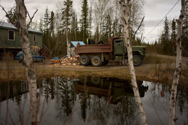 Nathan Moses, from left, Morris Demoski and Marissa McCarty deliver wood to an elder Monday, May 19, 2025, in Galena, Alaska. (AP Photo/John Locher)