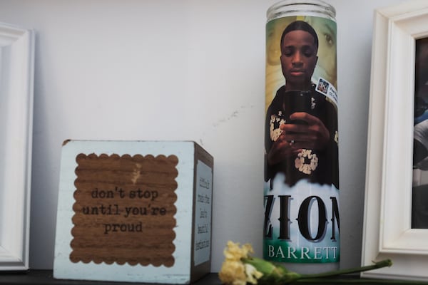 An image of Zion Barrett on a candle rests on a shelf in Deshaun Barrett's home in Locust Grove. (Abbey Cutrer / AJC) 
